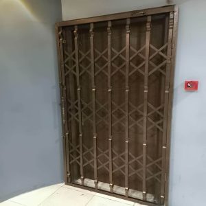 حفاظ آکاردئونی رنگ مشکی نصب شده روی پنجره ساختمان